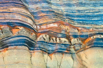 Abstract patterns of multicolored layered rock formation.