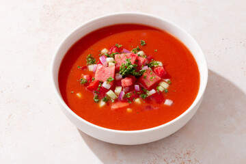 Spanish tomato and watermelon gazpacho cold soup styled and decorated in white plate