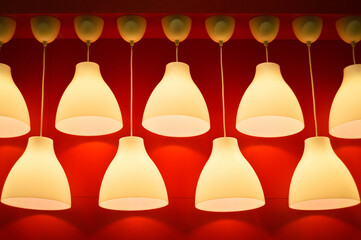 Many hanging lamps giving yellow and dim light on a red background
