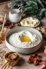 Baking ingredients and kitchen utensils on brown background. Flour, eggs, milk, honey, butter, spices for Gingerbread Cookies on kitchen table