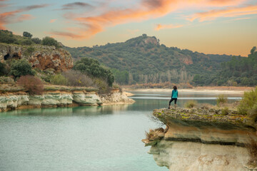 Person alone contemplating the lake from a cliff and enjoying nature in the lagoons of Ruidera