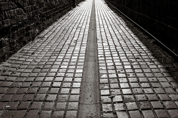 Stone laid private lane dating back many centuries seen in an ancient part of London, UK. A central...