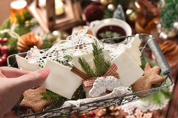 A wire basket with Christmas Eve wafer held above festive table with traditional dishes