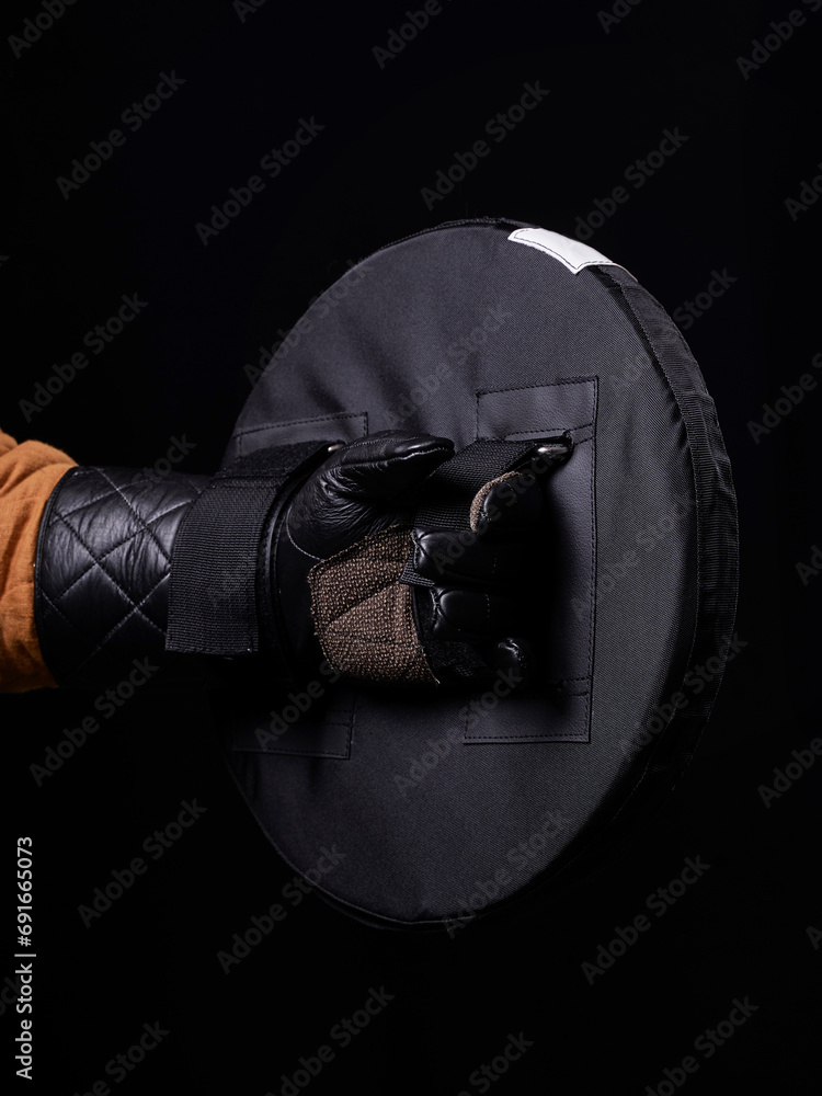 Wall mural man holding black sports soft round hema shield