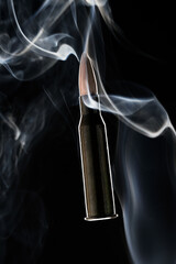 Rifle bullet in smoke on black background.