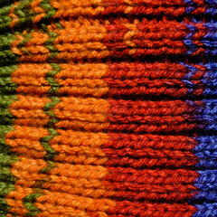 Handmade knitted fabric red blue and orange wool background texture