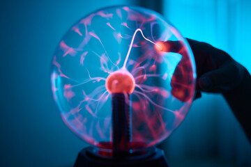 plasma ball. Hands holding plasma light ball. Plasma ball light ray science. Finger touching Plasma...