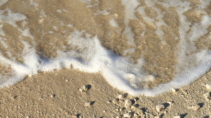 Fototapeta na wymiar Sand and sea with foam on the beach background