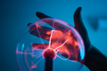 plasma ball. Hands holding plasma light ball. Plasma ball light ray science. Finger touching Plasma...