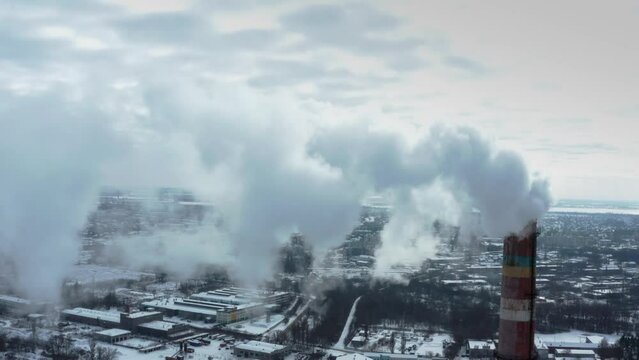 Pollution of the atmosphere by an industrial enterprise of the TPS station. Cloudy day in the winter. Smog smoke carbon and pollution emissions from industry smokestacks.  Cinematic footage