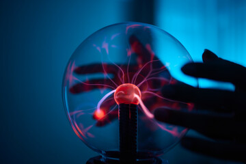 plasma ball. Hands holding plasma light ball. Plasma ball light ray science. Finger touching Plasma...