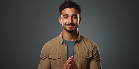 A man in a brown shirt is seen making a gesture. This image can be used to depict communication, body language, or expressing emotions