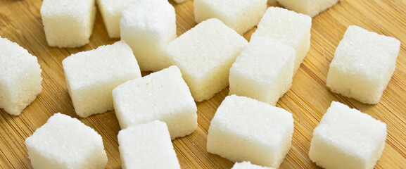 White sugar cubes on bamboo cutting board, sugar cubes texture