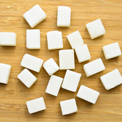 White sugar cubes on bamboo cutting board, sugar cubes texture
