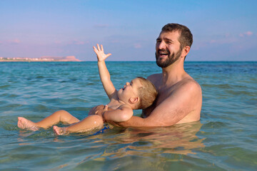 Joyful father and son having fun in water on  beach.Summer vacation.Happy lifestyle childhood concept