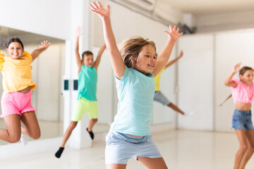 Fototapeta na wymiar Portrait of satisfied boys and girls jumping having fun after dance class