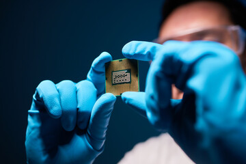 Cropped image of an engineer showing a computer microchip on the foreground