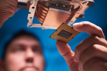 Cropped image of an engineer showing a computer microchip on the foreground