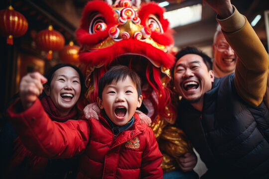 Cheerful Asian family celebrating Chinese New Year. Happy parents and kids having fun during New Year celebration in Asian town.