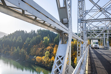 Heavy duty day cab rig semi truck with dry van semi trailer transporting cargo driving on the...