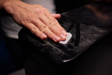 caucasian hand with dust on finger tips after touching black dusty surface, closeup with selective focus
