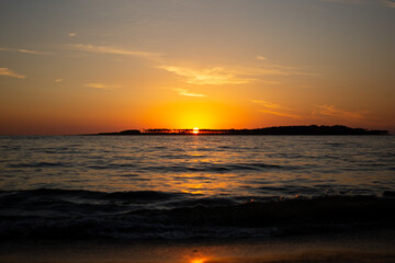 Coastal sunset in Uruguay with orange sky and waves
