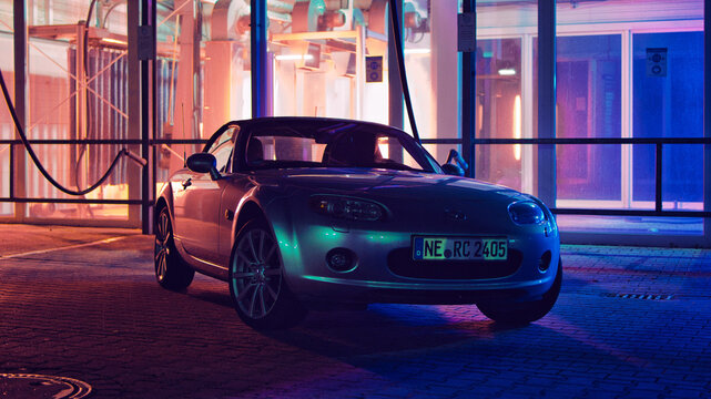 Mazda MX5, Miata, NC at night in front of a red and blue illuminated carwash