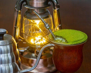 Traditional chimarrão prepared with yerba mate (Ilex paraguariesis) in a porongo gourd, next to a...