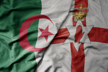 big waving national colorful flag of northern ireland and national flag of algeria .