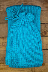 Handmade wool knitted winter blue hat and scarf isolated on old wood background
