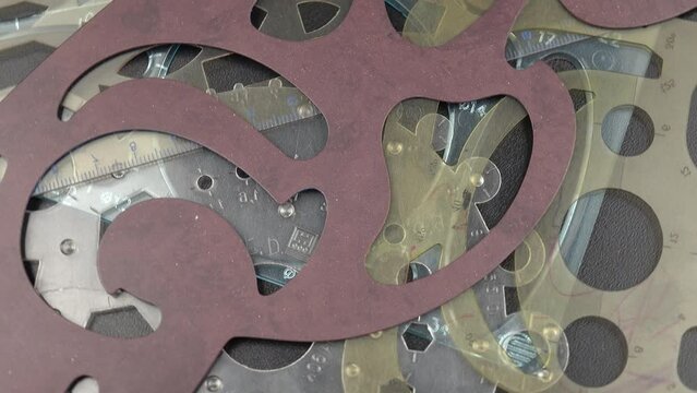 Set of various plastic french curve rulers, drawing curve templates lie on a black table