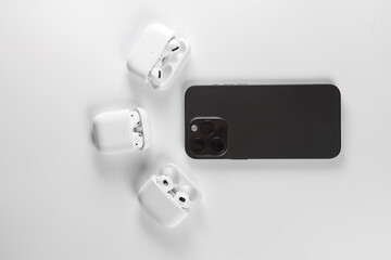 black smartphone with white wireless headphonesб  Iphone 15 pro max Black Titanium - obrazy, fototapety, plakaty