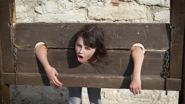 Child in guillotine. A child have joyful mood at festival and put her head in guillotine.
