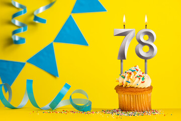 Lighted birthday candle number 78 - Yellow background with blue pennants