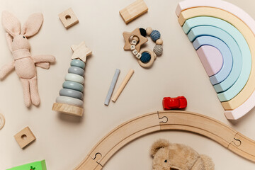 Wooden kids toys on pastel paper.  Educational toys blocks, pyramid, pencils, bear, bunny, train. Toys for kindergarten, preschool or daycare. Copy space for text. Top view	 - obrazy, fototapety, plakaty