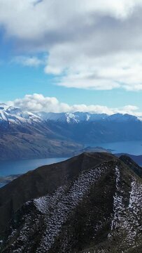 Orbital shot with a person from the top of Roys Peak on a sunny day