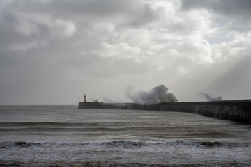 Stormy weather in Newhaven, East Sussex, England in autumn. View of the jetty and the lighthouse.