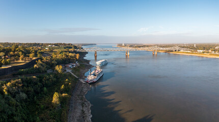 Modern Mississippi cruise boat and traditional riverboat docked by the bluff under the hill in...