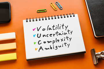 There is notebook with the word Volatility Uncertainty Complexity Ambiguity. It is as an...