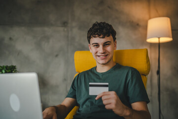 teenager young man at home use credit card shopping online e-banking