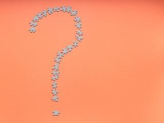 Question Mark Made of Puzzle Pieces on an Orange Background, Concept of Curiosity and Riddles