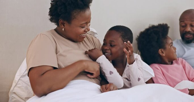 Happy, tickling and black family having fun in bed together at modern home for bonding. Smile, love and African mother and father playing, laughing and being crazy with kids in the bedroom of house.