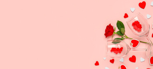 Wineglasses, rose and hearts on pink background with space for text. Valentine's Day celebration