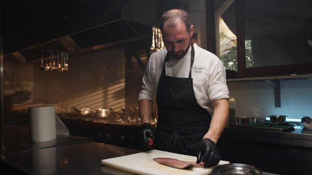 Cook Filleting a Fish on the white cutting board of the restaurant