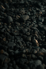 Black volcanic rocks, porous stones on a beach, pebbles,