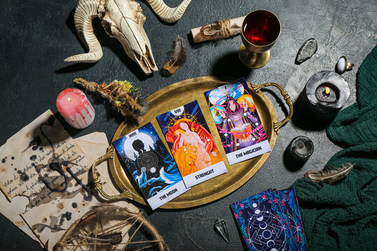 Witch's magic attributes with tarot cards, skull of sheep and burning candles on dark table