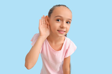 Little girl trying to hear something on blue background