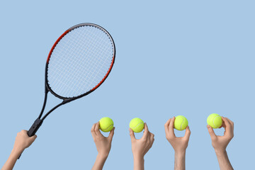 Female hands with racket and tennis balls on blue background