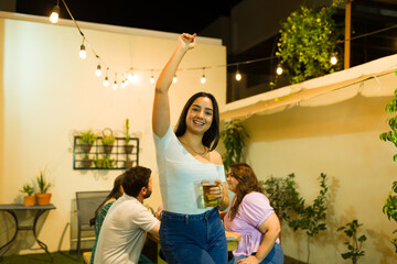 Attractive latin woman excited having fun with friends drinking beer