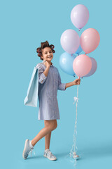 Little girl with hair curlers, shopping bag and balloons on blue background